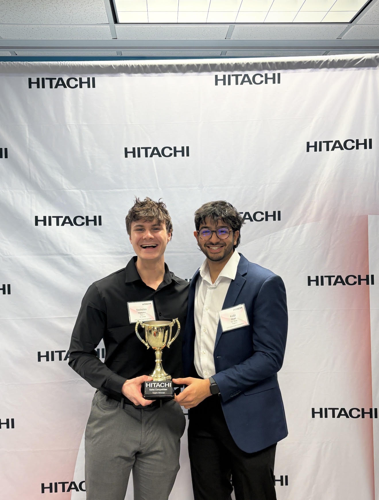 KNB Creative team members holding a sales competition trophy